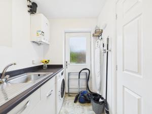 a white kitchen with a sink and a window at Spacious 5 Bed Contractor Hub 3 Baths Corby in Corby