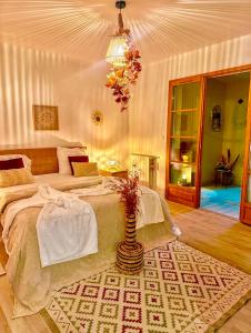 a bedroom with a large bed and a vase on a rug at Grande maison romantique avec jacuzzi intérieur & parking, à 1h30 de Paris in Montbouy