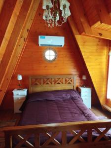 a bedroom with a bed in a wooden attic at La cabañita de Lali in Monte Hermoso