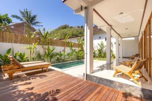an outdoor deck with chairs and a swimming pool at Villa Suka in Kuta Lombok