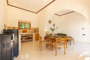 een keuken en eetkamer met een tafel en stoelen bij Villa Suka in Kuta Lombok +4 foto's
