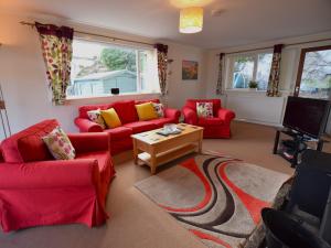 a living room with red couches and a tv at 2 bed in Lochgilphead AG692 in Tayvallich