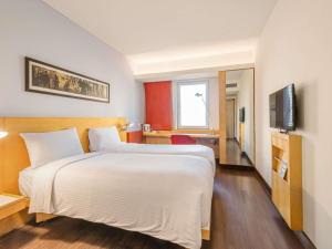 a hotel room with a large bed and a television at ibis Bengaluru Hosur Road - An Accor Brand in Bengaluru +82 photos