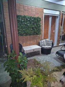 a patio with a bench next to a brick wall at Seu cantinho a dois quarteirões da Praia in Guarujá +5 photos