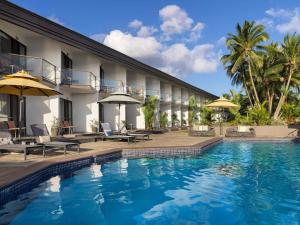 a hotel with a swimming pool in front of a building at Novotel Suva Lami Bay in Suva