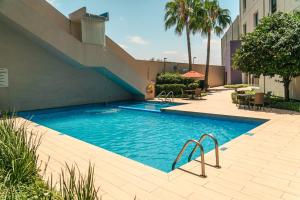 a swimming pool with a staircase next to a building at Crowne Plaza Monterrey Aeropuerto by IHG in Monterrey