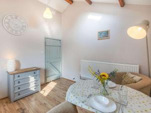 a room with a table with a vase of flowers on it at 1 Bed in Barnstaple 09090 in Umberleigh Bridge