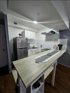 a kitchen with a wooden counter top and a refrigerator at Teatinos Departamentos STGO in Santiago +2 photos
