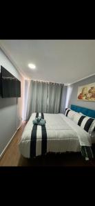 a bedroom with a bed with a striped blanket at Teatinos Departamentos STGO in Santiago
