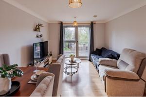 a living room with a couch and a table at Contractor-Friendly, Private Gated Parking, Fast WiFi, Sofa Bed & Netflix, 5-Min Walk to City Centre, 15-Min Walk to Train Station, Ideal for Relocators & Families in Coventry