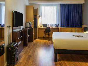 a hotel room with a bed and a television at ibis Genève Petit Lancy in Geneva