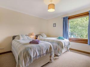 a bedroom with two beds and a window at 3 Bed in Aberfeldy 50619 in Dunkeld