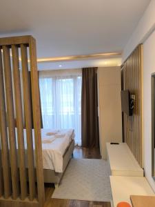 a bedroom with a bed and a tv in a room at Jasmin President Kop in Kopaonik