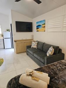 a living room with a couch and a tv at Villa La Sini Yeppoon in Yeppoon