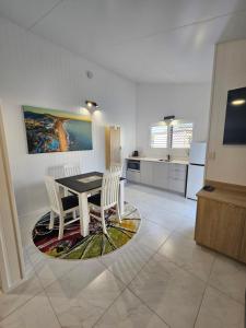 a kitchen and dining room with a table and chairs at Villa La Sini Yeppoon in Yeppoon