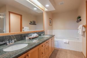 a bathroom with two sinks and a tub and a mirror at Snowcreek V 756 in Mammoth Lakes