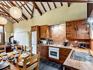 una cucina con armadi in legno e un tavolo con sala da pranzo di 3 Bed in Ilfracombe GRAIC a West Down