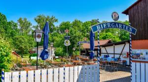 a restaurant with a white fence and a blue gate at Hotel und Restaurant Nehrener Hof in Nehren