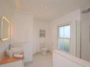 a white bathroom with a sink and a toilet at 5 Bed in Sandown 87008 in Sandown +29 photos