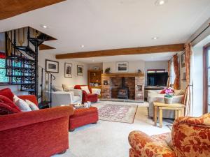 Una sala de estar con muebles rojos y chimenea. en 4 bed in Cheltenham 41216, en Tirley