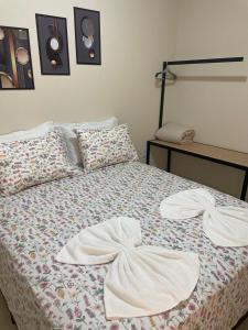 a bed with two white towels on top of it at Apartamento individual em Sinop 12 in Sinop