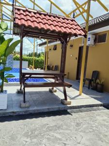 a picnic table with a roof on a patio at Cikgu CTZ Homestay A in Kampung Raja
