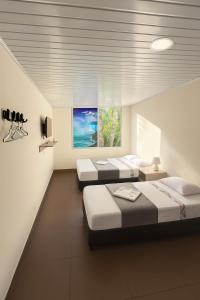 a room with three beds and a window at Hotel Arboleda de Cádiz in Ibagué +11 photos