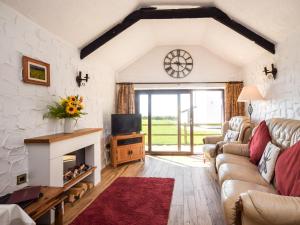 Il comprend un salon doté d'un canapé, d'une télévision et d'une cheminée. dans l'établissement 2 Bed in Rhossilli 89302, à Rhossili