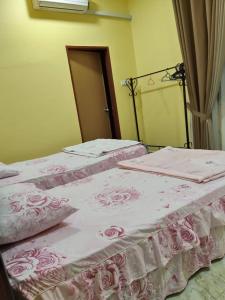 two beds sitting next to each other in a room at Cikgu CTZ Homestay A in Kampung Raja