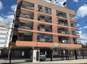 een gebouw met balkons en een hek ervoor bij Apartamento Alpha Premium 209 in Ubatuba