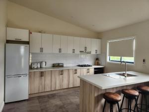 a kitchen with a white refrigerator and wooden cabinets at Seaspray Caravan Park in Seaspray