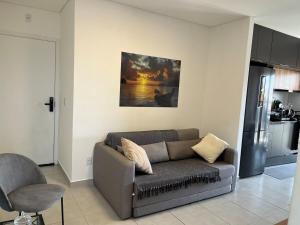 een woonkamer met een bank en een keuken bij Apartamento Alpha Premium 209 in Ubatuba