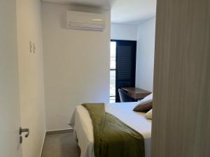 een slaapkamer met een bed, een raam en een deur bij Apartamento Alpha Premium 209 in Ubatuba +61 foto's