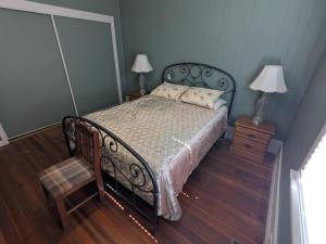 a bedroom with a bed and a chair and two lamps at MinCo Properties WV, Carswell Hollow Overlook in Kimball