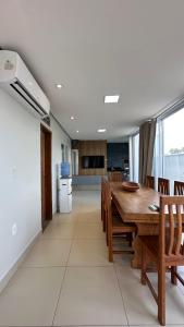 a kitchen and dining room with a wooden table and chairs at Casa Gold Condominio Estancia Jussara in Barreirinhas
