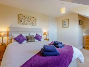 Un dormitorio con una cama grande con toallas moradas. en 2 bed in Totland Bay IC003, en Freshwater