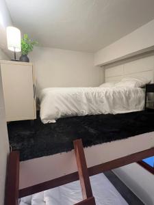 a bedroom with a bed with white sheets and a black rug at Casa Luna Royale in San Juan