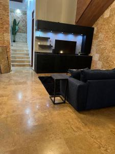 a living room with a couch and a television at Casa Luna Royale in San Juan
