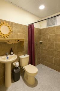 a bathroom with a toilet and a sink and a shower at Hotel Arboleda de Cádiz in Ibagué