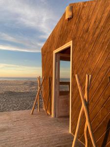 a wooden building with an open door on the beach at La Pointe d'Or Hotel Dakhla in Dakhla