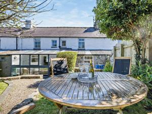 a wooden table in the garden of a house at 3 Bed in Nefyn 55571 in Nefyn