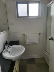 a white bathroom with a sink and a window at Seaspray Caravan Park in Seaspray +31 photos