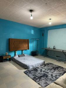a bedroom with a bed and a blue wall at Loft en Puebla in El Gallinero