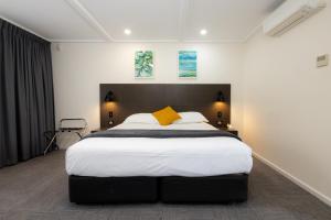 a bedroom with a large bed with a yellow pillow at Mick O'Sheas in Hackham