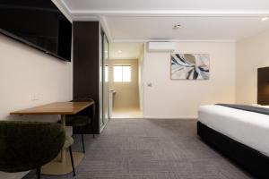 a hotel room with a bed and a desk at Mick O'Sheas in Hackham