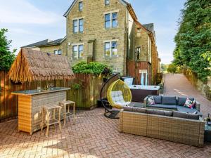 a patio with a couch and a grill and a house at 5 Bed in Haworth 88390 in Oxenhope