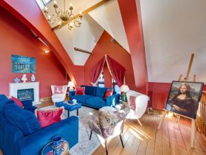 a living room with red walls and blue couches at 5 Bed in Haworth 88390 in Oxenhope