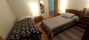 a small bedroom with a bed and a mirror at Patagonia Mágica in Punta Arenas
