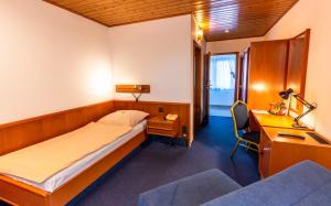 a hotel room with a bed and a desk and a desk at Hotel und Restaurant Nehrener Hof in Nehren