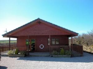a small wooden cabin with a fence in front of it at 4 Bed in Clovelly 00356 in Clovelly